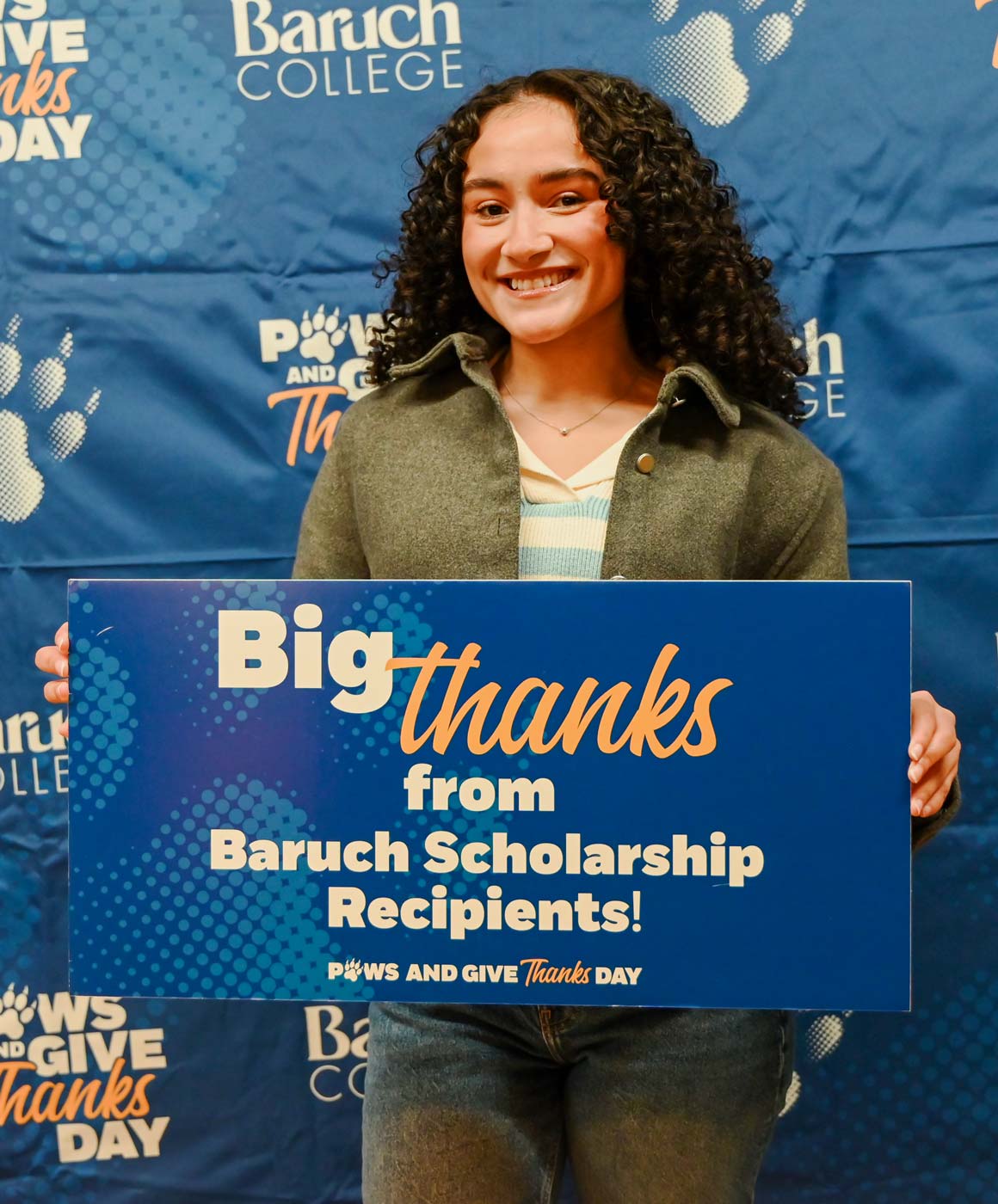 Baruch student holding up a sign with a note of gratitude for Baruch donors