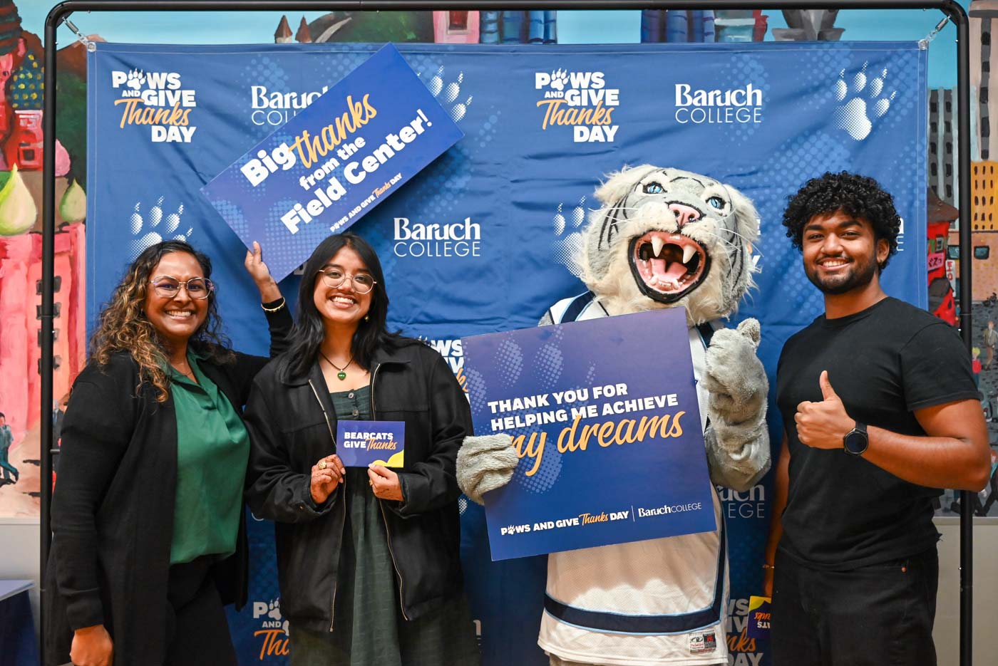 Baruch students and mascot holding up a sign with a note of gratitude for Baruch donors