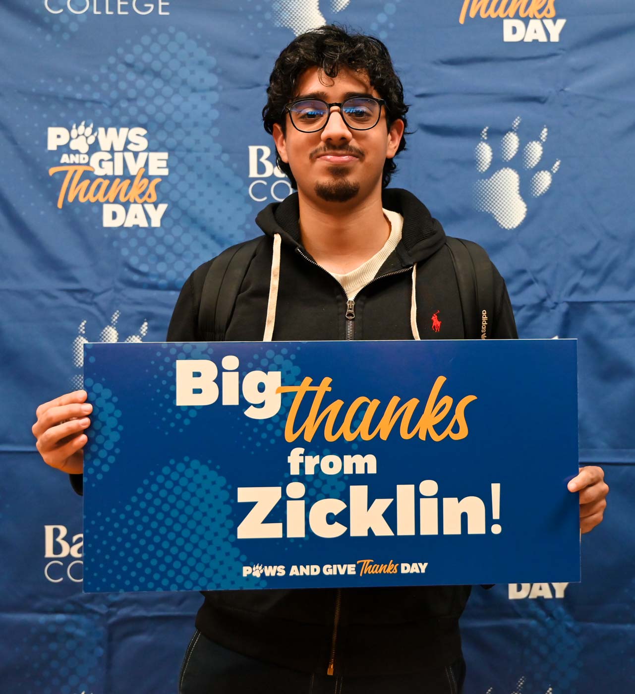 Baruch student holding up a sign with a note of gratitude for Baruch donors