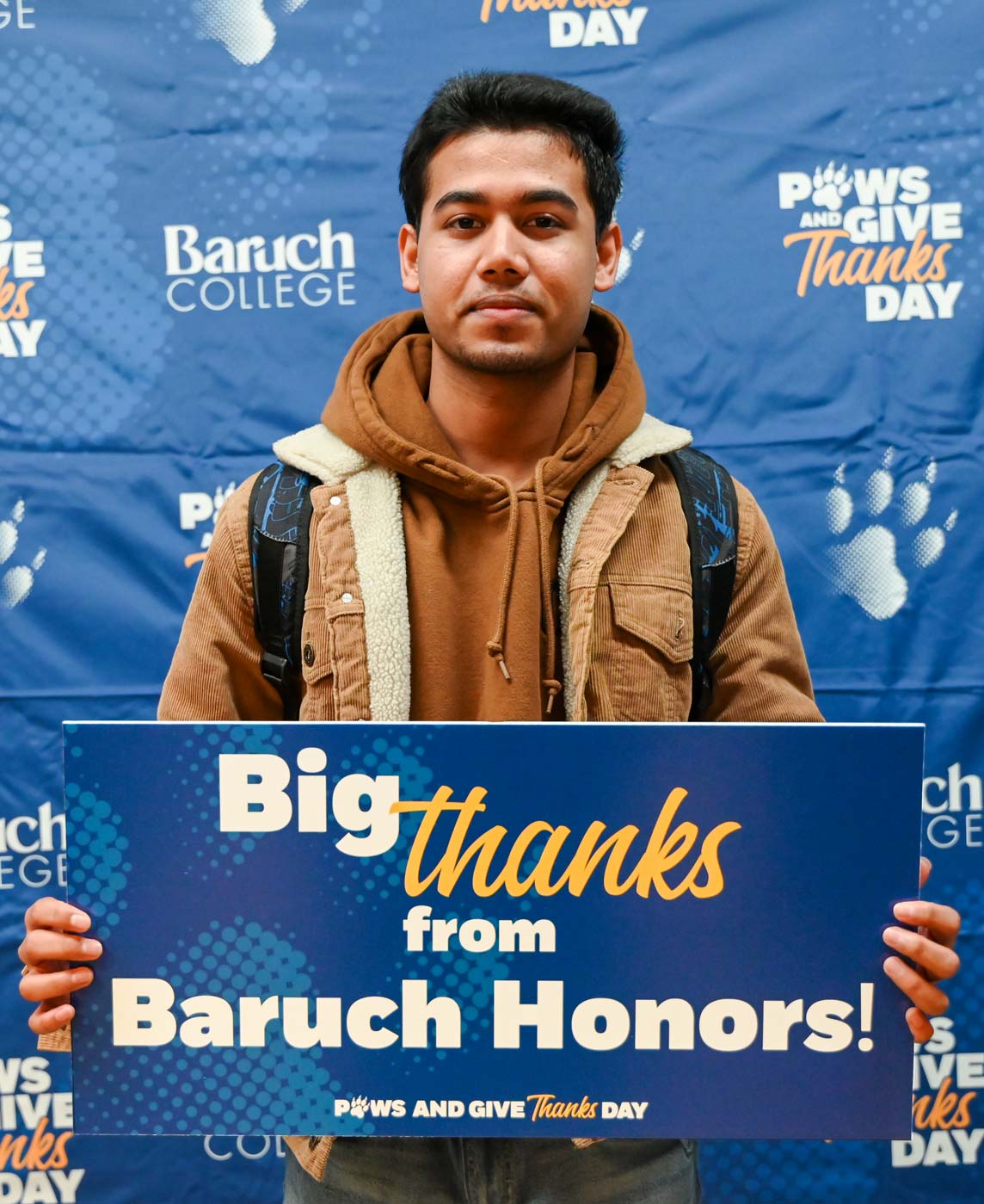 Baruch student holding up a sign with a note of gratitude for Baruch donors