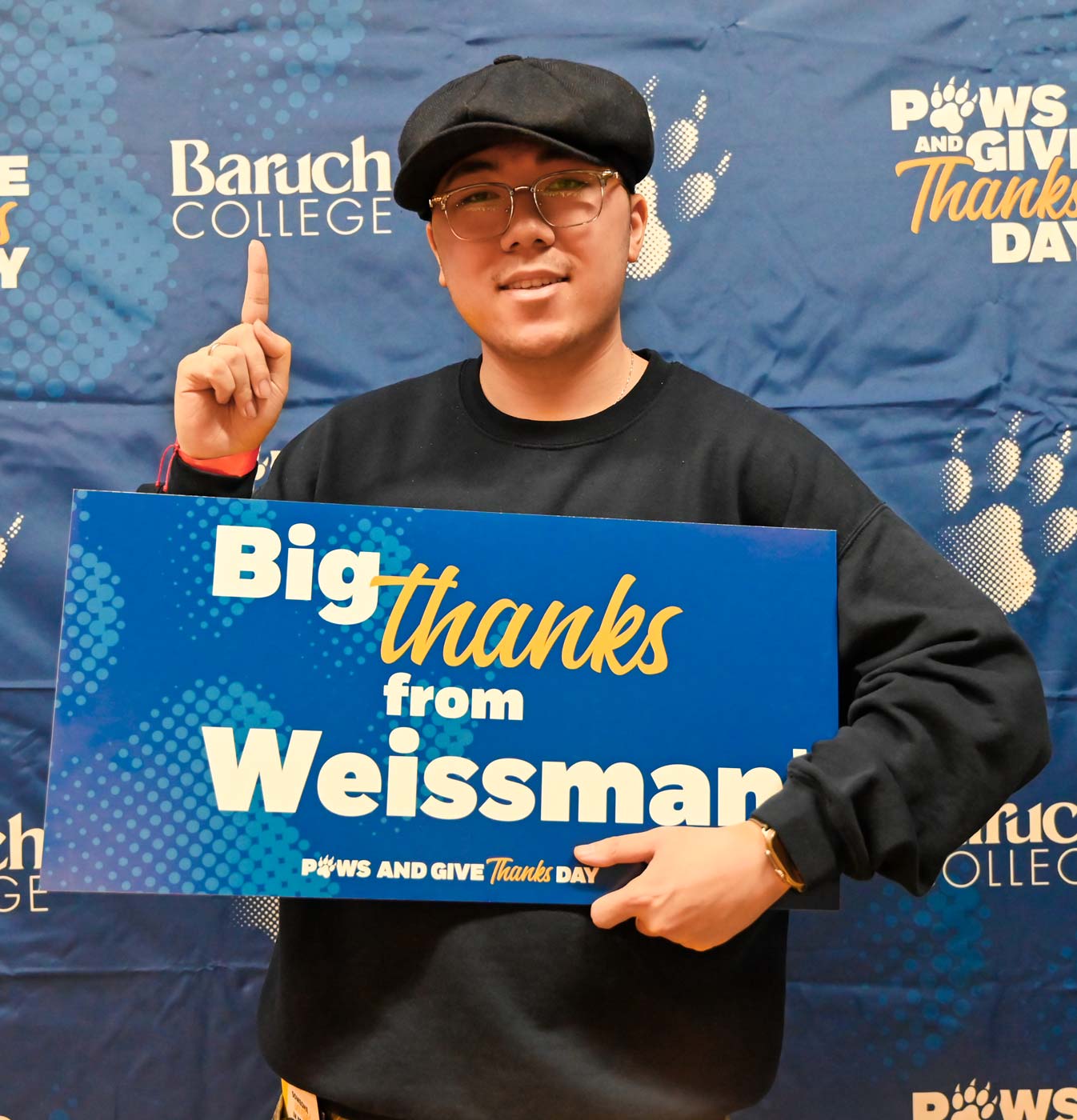 Baruch student holding up a sign with a note of gratitude for Baruch donors