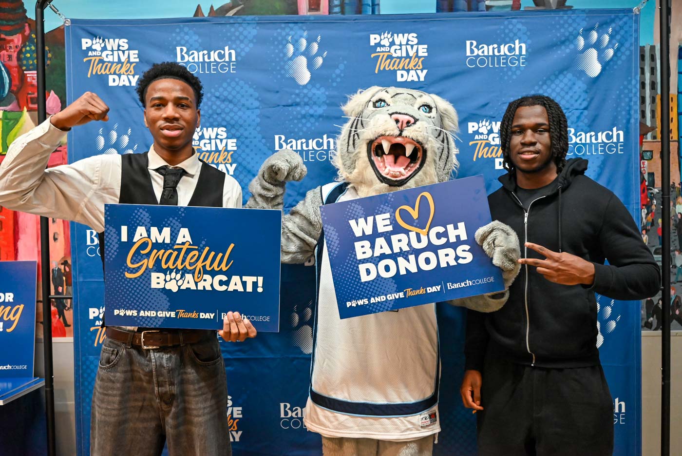 Baruch students and mascot holding up a sign with a note of gratitude for Baruch donors