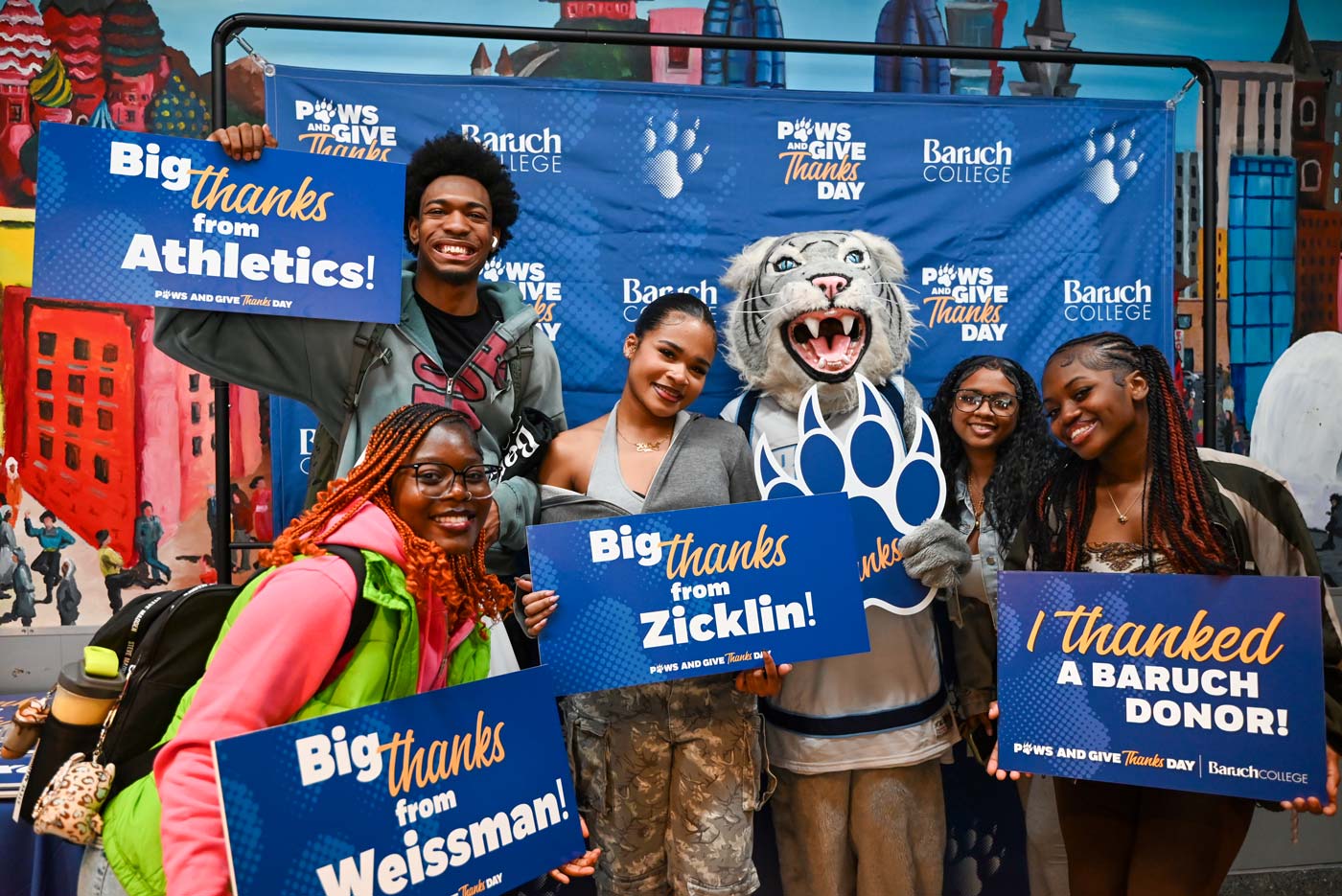 Baruch students and mascot holding up a sign with a note of gratitude for Baruch donors