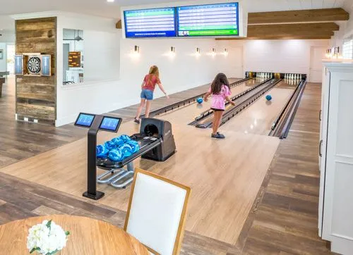 Two girls bowling on a private bowling alley