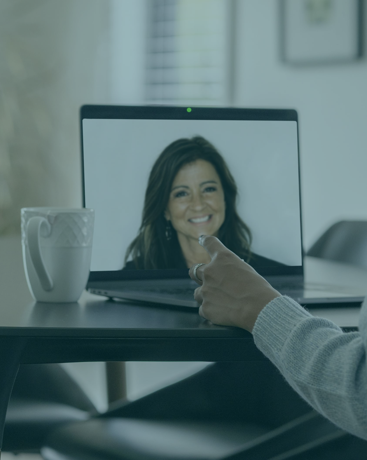 Person having a virtual consultation with a physician via video call on a laptop screen