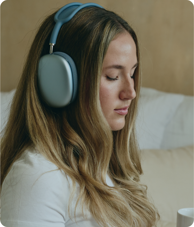 Someone outdoors beside a pool balances in a yoga pose while wearing headphones, looking focused and serene.