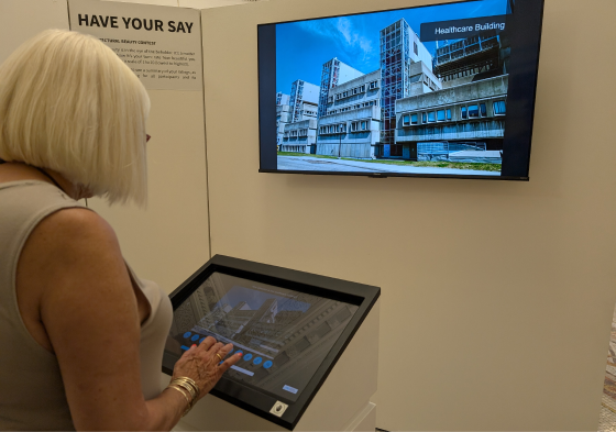 A visitor interacting with the touchscreen plinth.