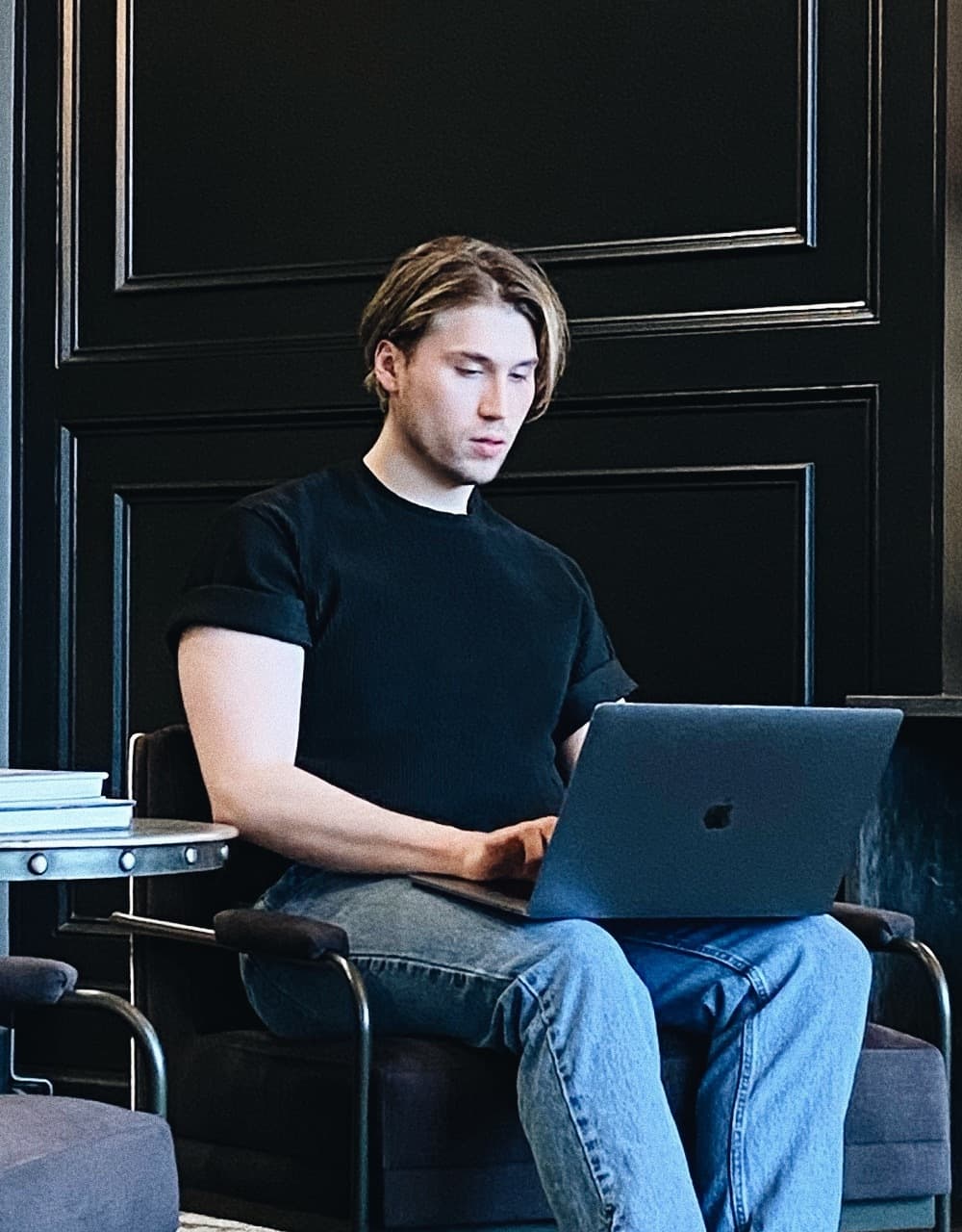 Liam sitting in a chair, looking at his laptop.