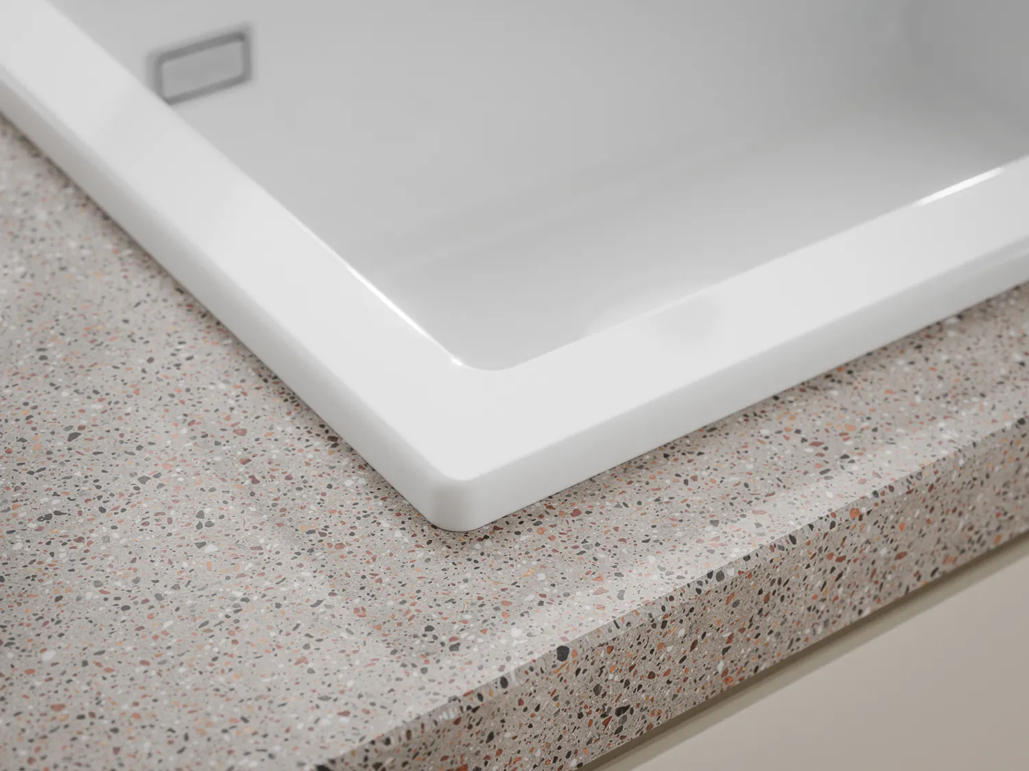 Naber Silqua Keramikspüle in Weiß in einer Küche, Detailaufnahme einer abgerundeten Ecke.