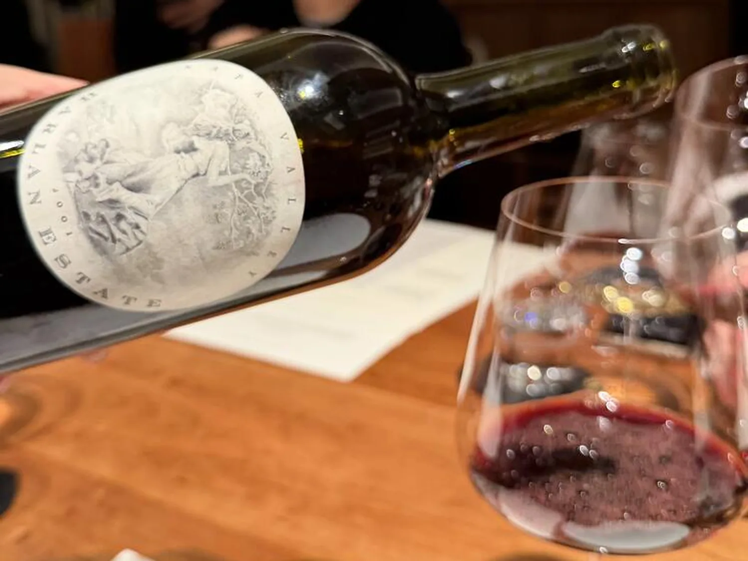 Harlan Estate bottle and red wine glass at a Mosu x Harlan dinner.