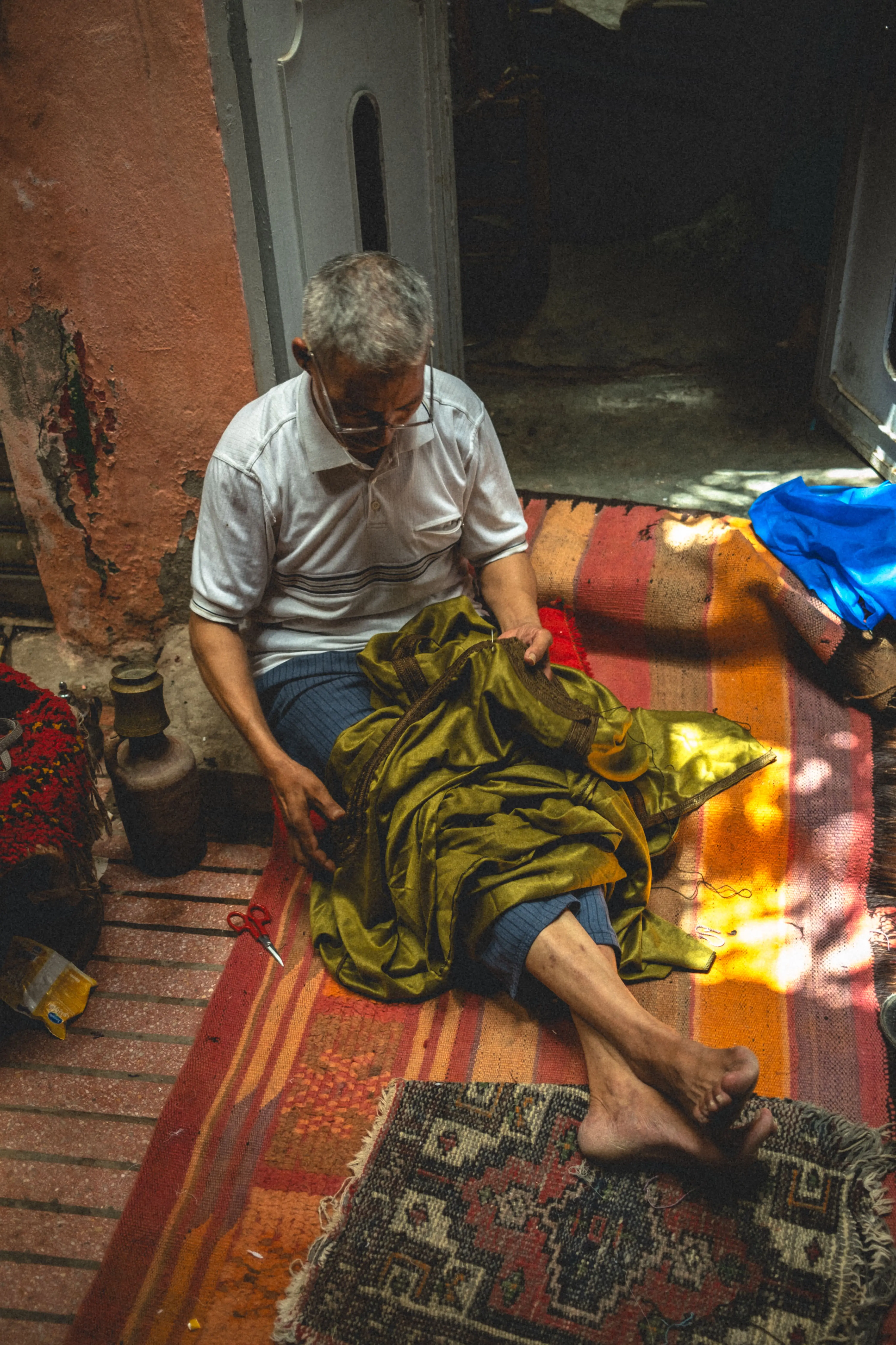 An old man sewing traditional clothing