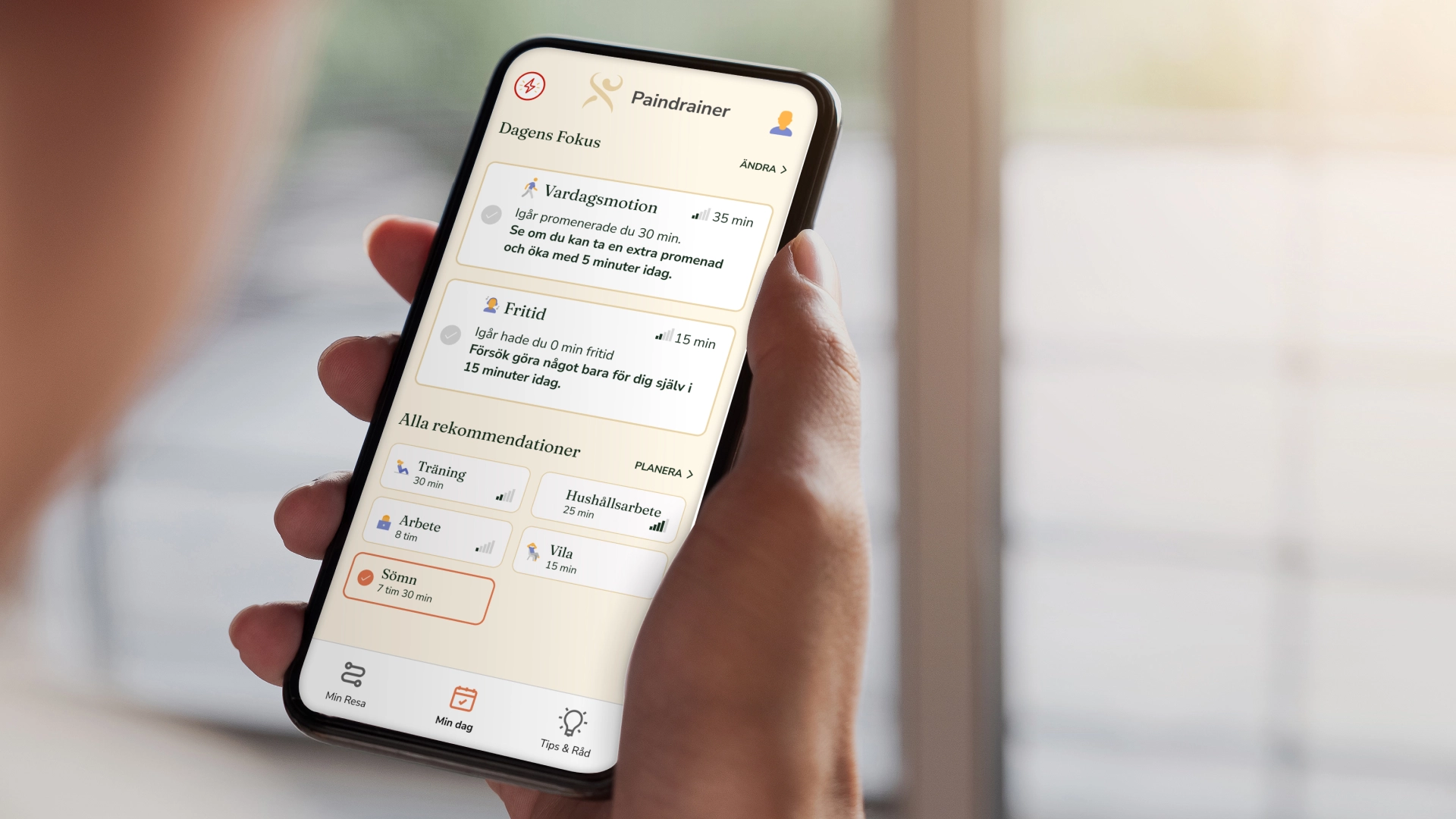 Hand holding a smartphone showing a health and wellness app with daily focus and activity recommendations.