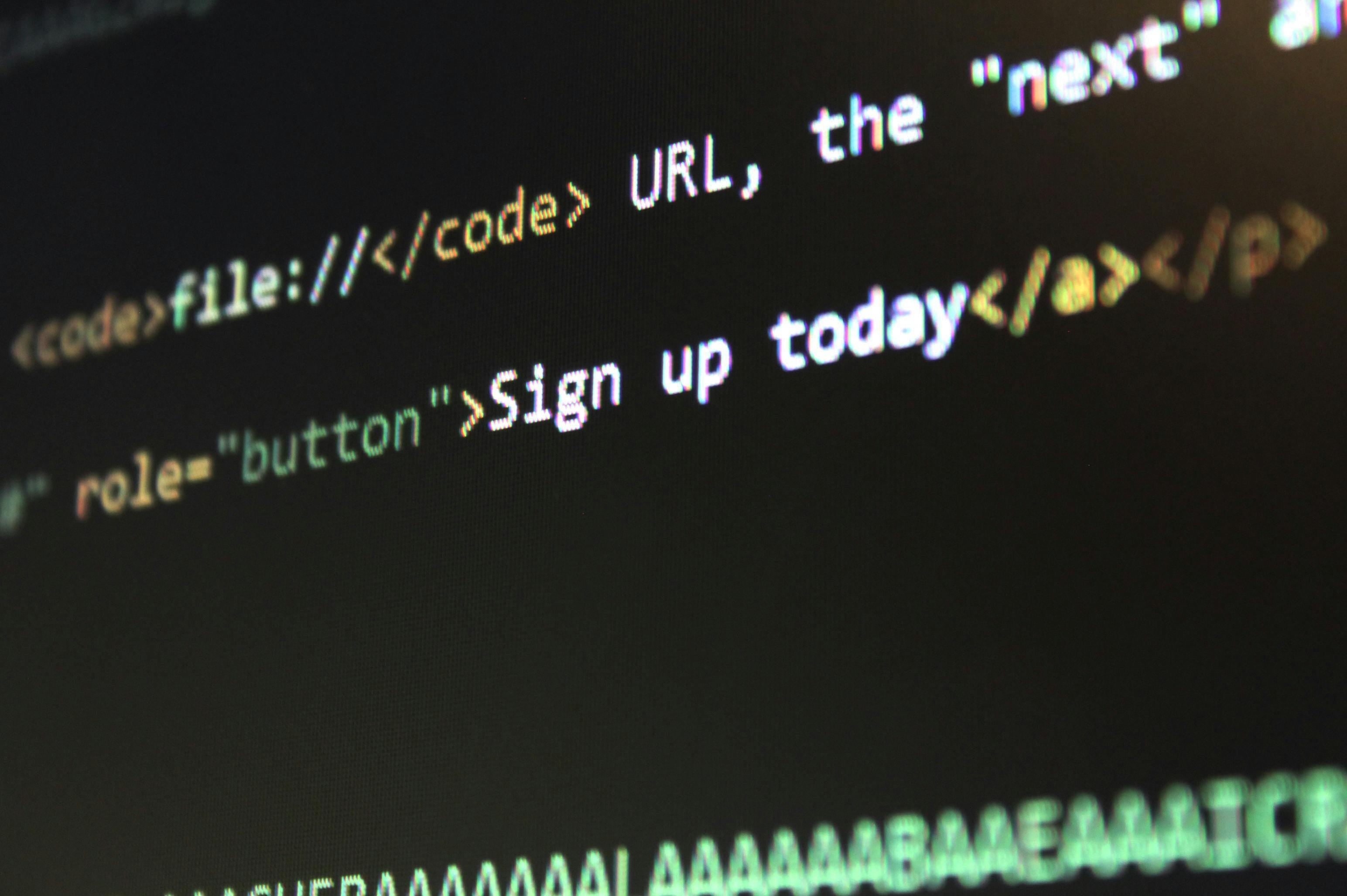 Code on a computer screen with HTML text and a URL.