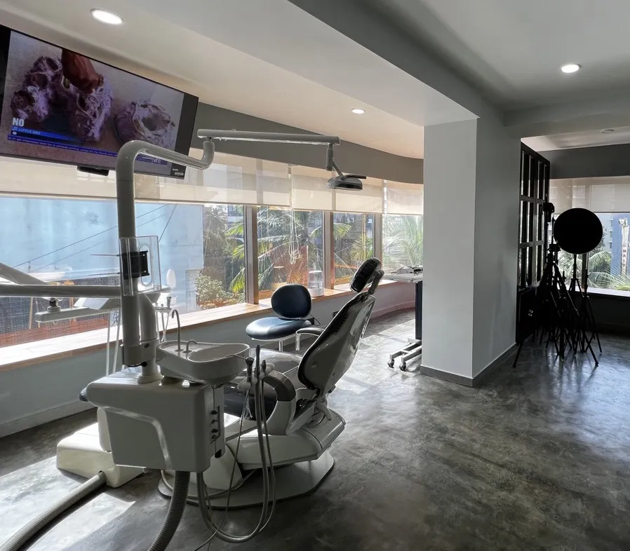 Bright treatment room with a dental chair and large windows