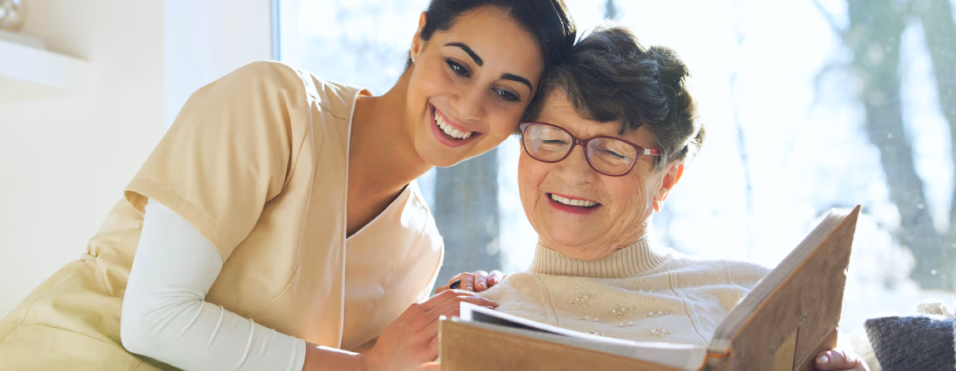 A caregiver and her  patient looking at photographs.