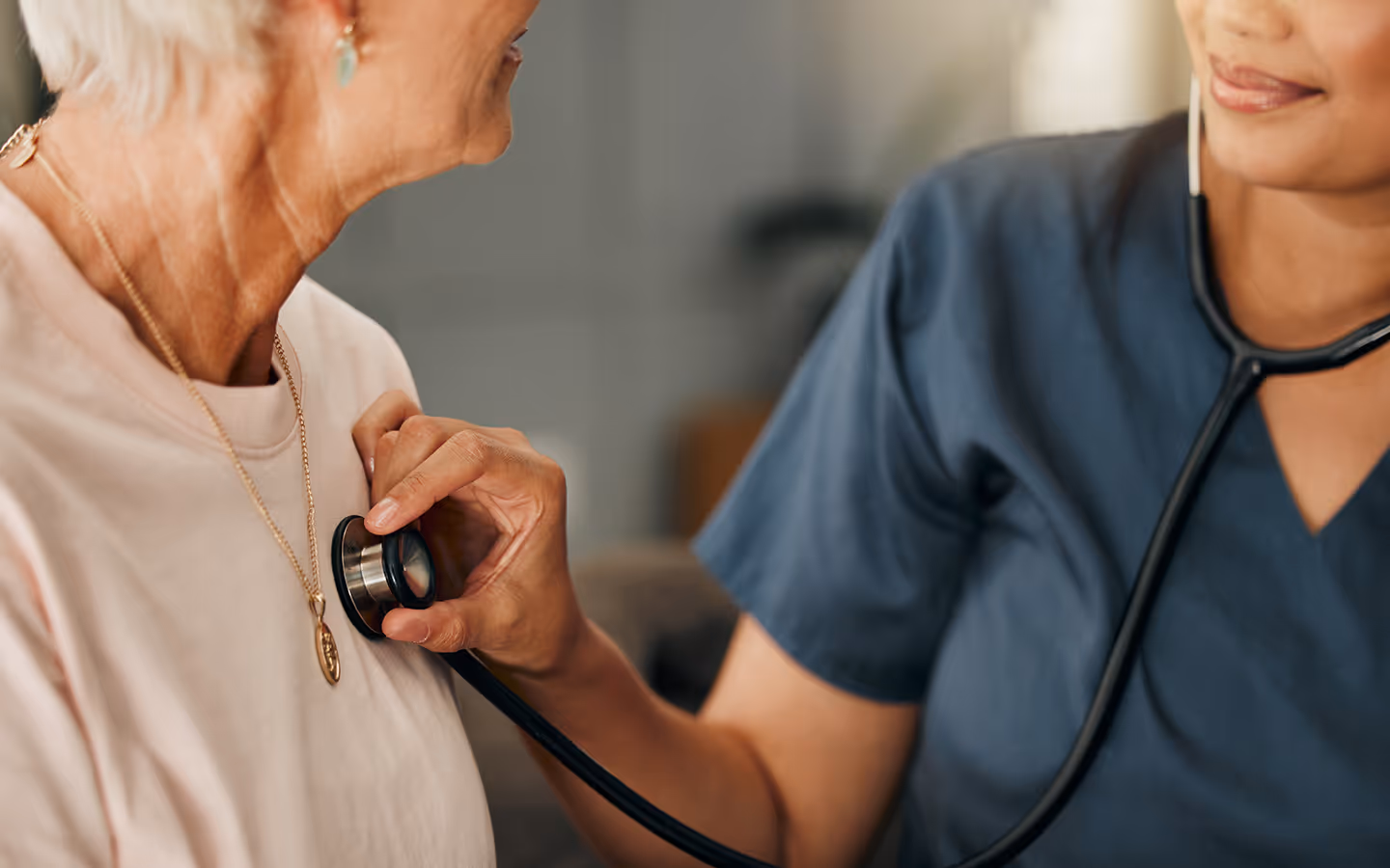 A nurse listening to her patient's heart.