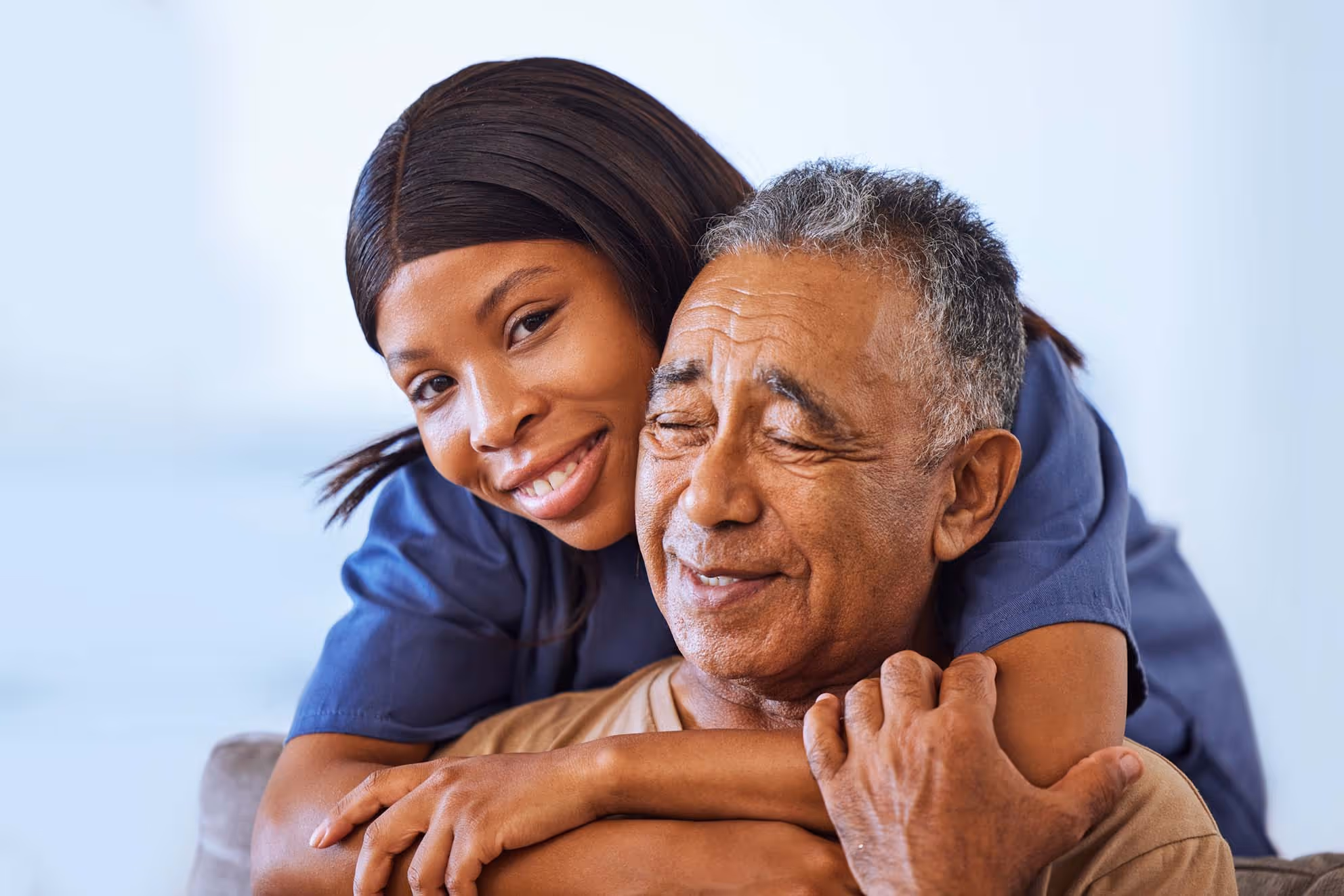 Caregiver hugging a senior patient.