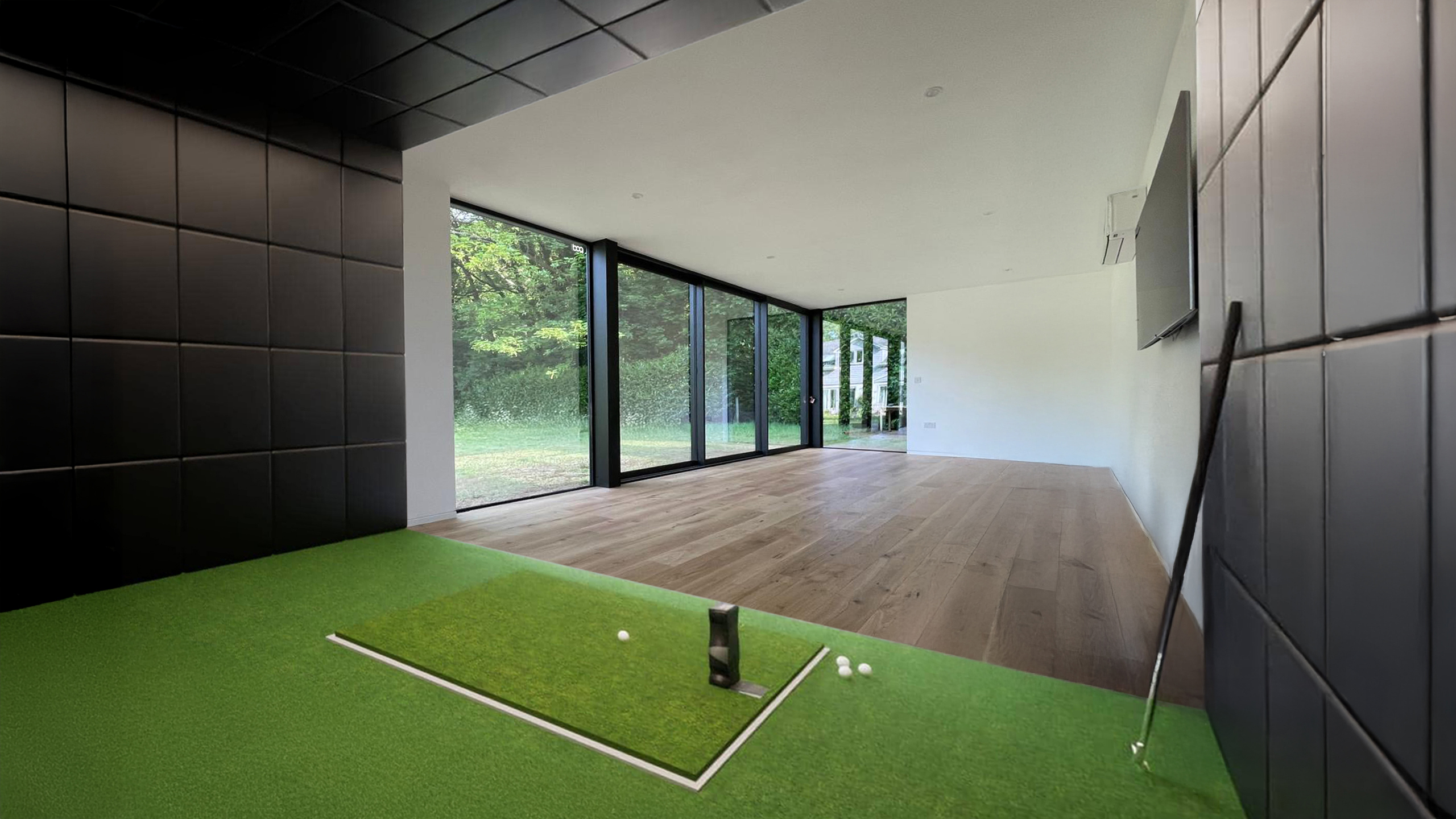 Modern open plan garden building with putting green area and full height glazing.