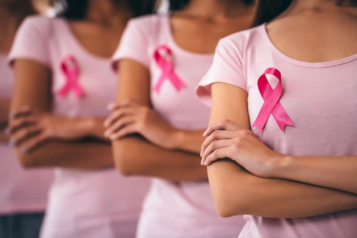 Femmes en t-shirt rose avec ruban d’Octobre Rose sur la poitrine, engagées pour la lutte contre le cancer du sein.
