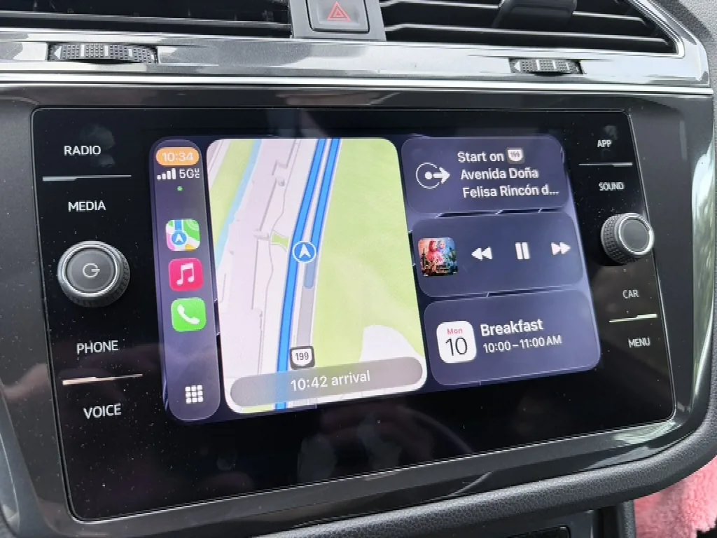 Volkswagen infotainment screen showing the Apple CarPlay Dashboard view with Maps navigation on the left and media controls plus a calendar reminder on the right