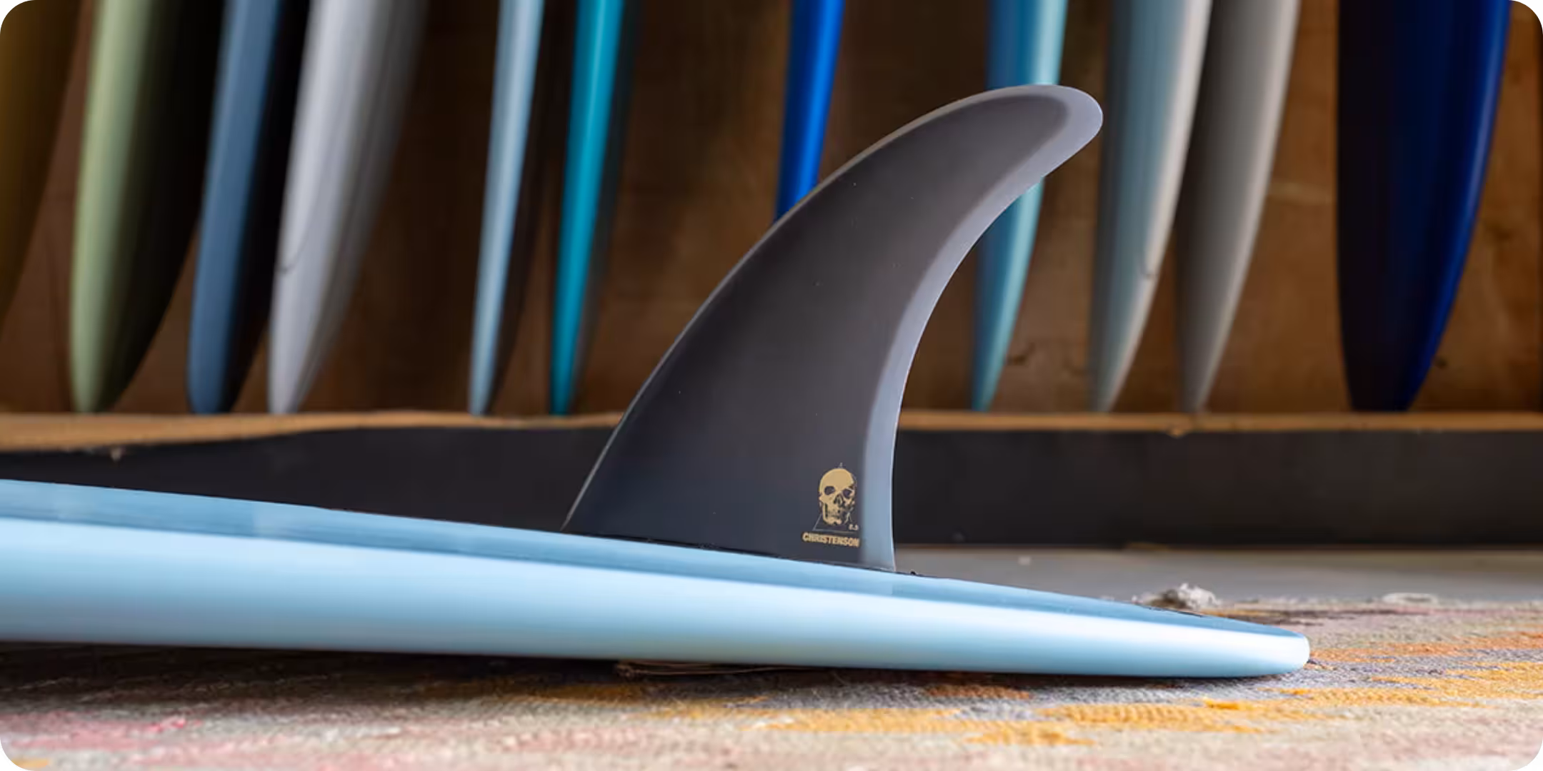 A Christenson long board on its back with the fin up