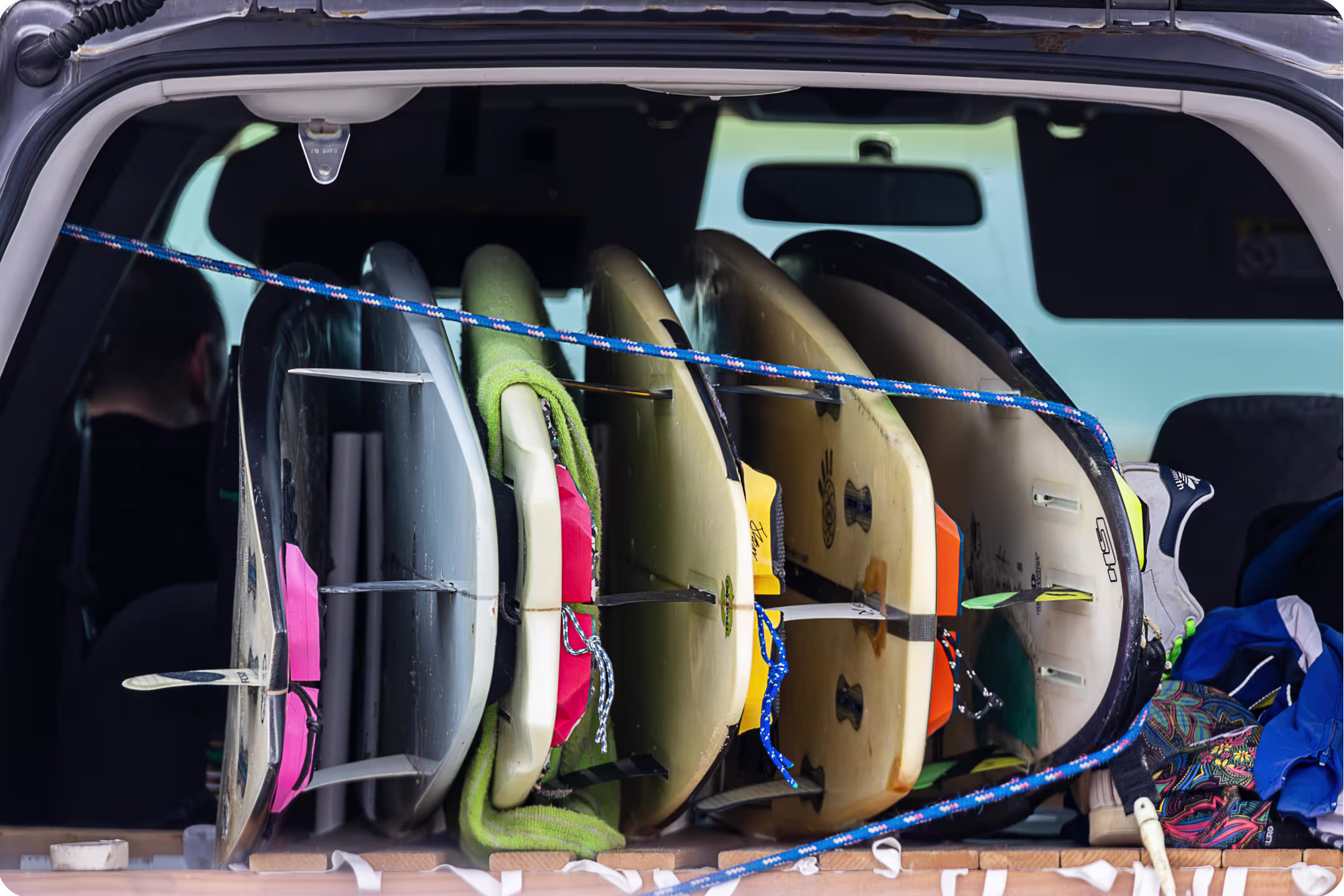 Surfboards in the back of a car tied to each other with a rope