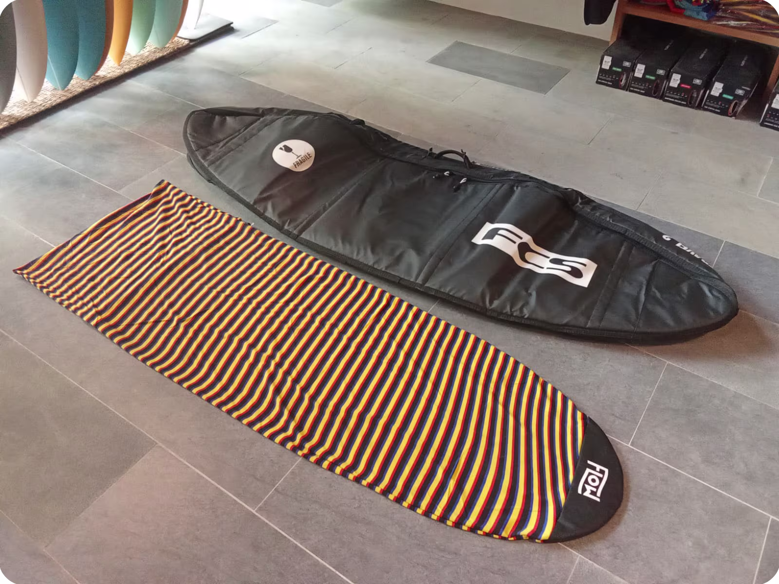A surfboard bag and sock on display at Flow Surf Lombok