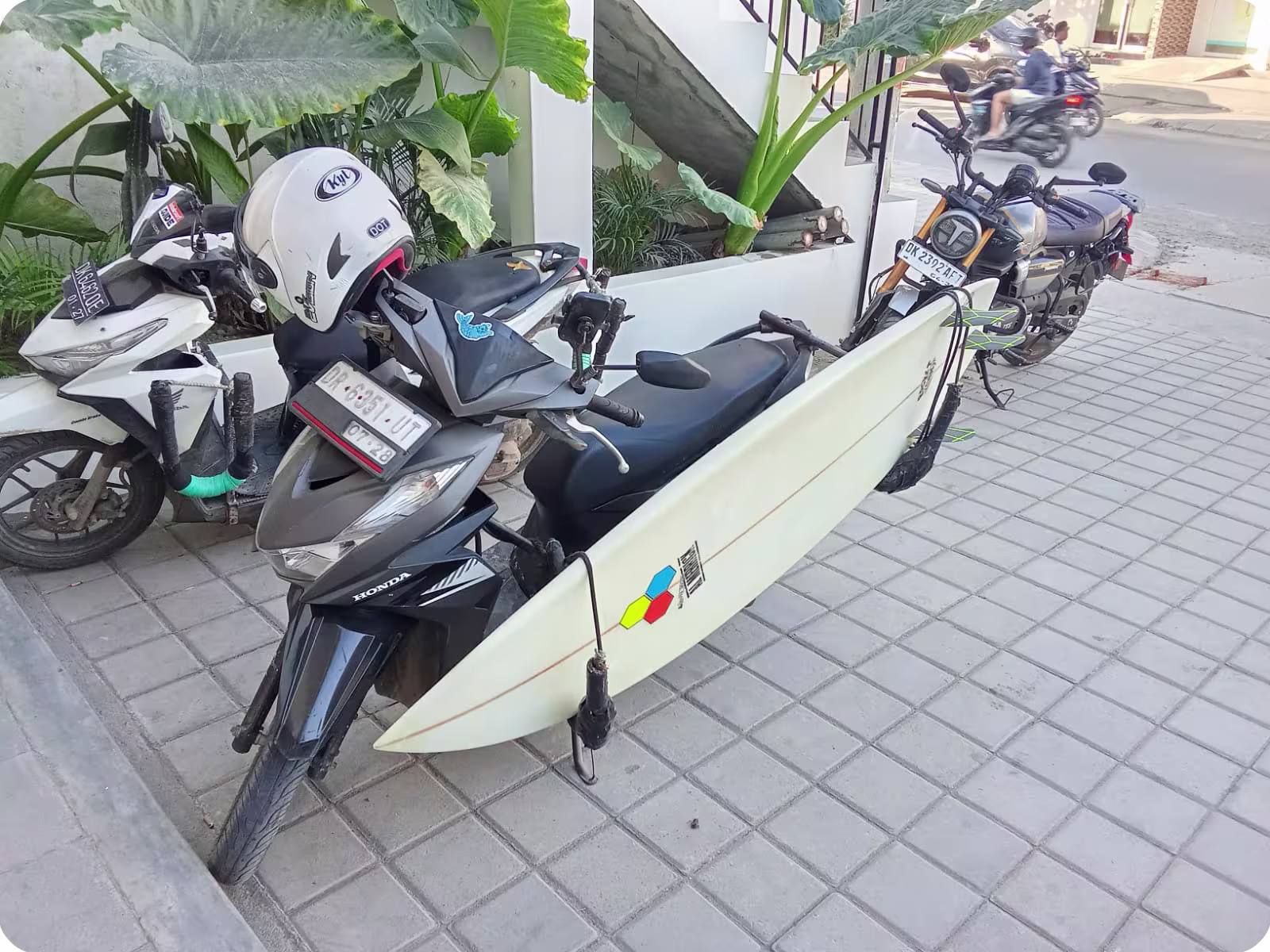 Channel Islands surfboard on a motorbike rack in front of Flow Surf Lombok