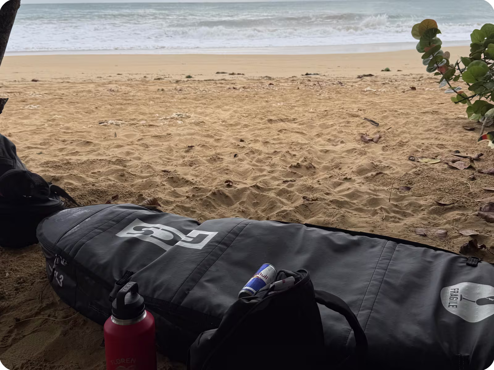 An FCS surfboard bag on a beach
