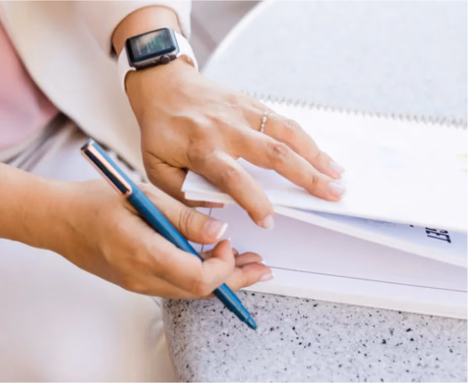 A hand with a pen and notepad