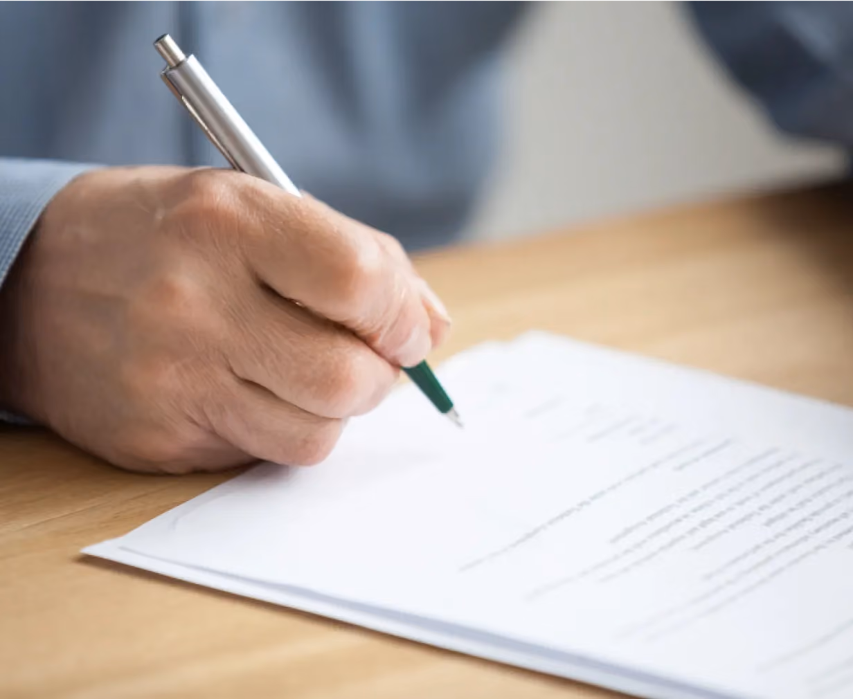 A hand with a pen and notepad