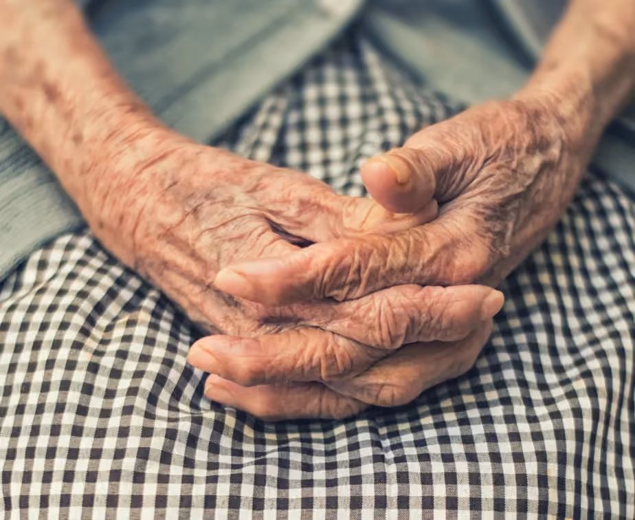 Old woman's hands clasped on her knees