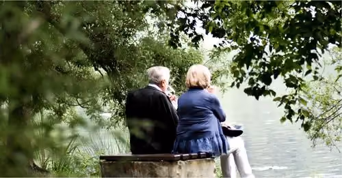 Elderly couple sitting on a park bench