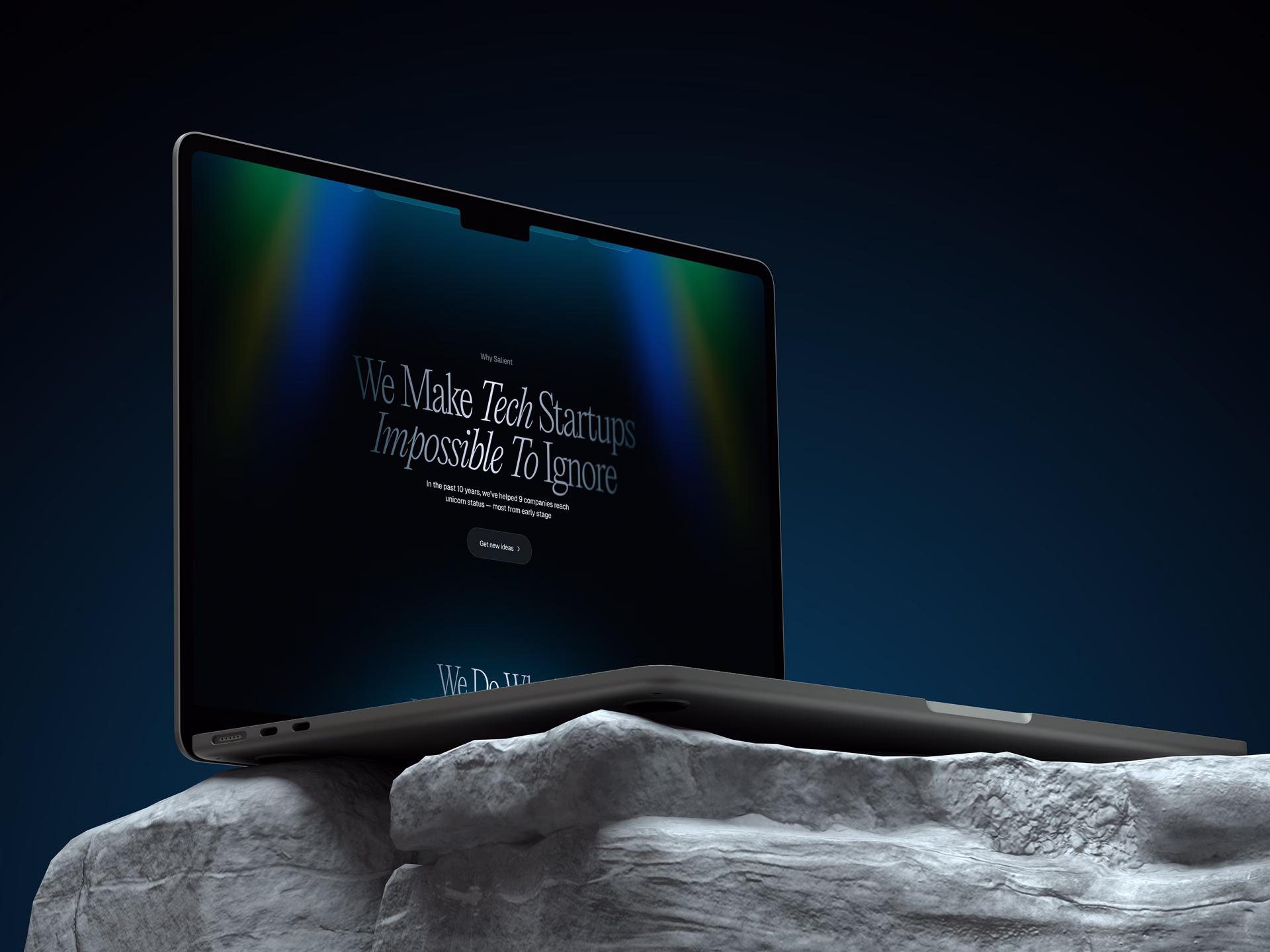 Angled laptop displaying a green vitamin supplement website, perched on a rugged gray rock against a dark background; modern, polished tone.