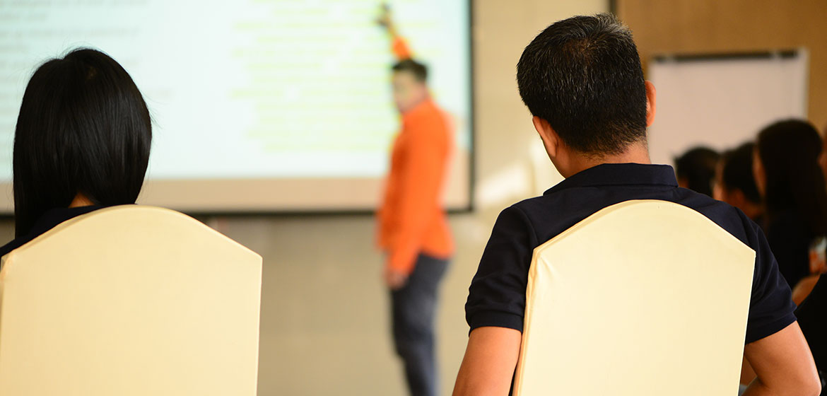 Bayer participants watching a presenter in an orange shirt at a Genius Journey session