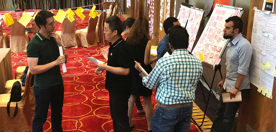 Covestro Shanghai participants discussing idea posters on a wall covered in sticky notes