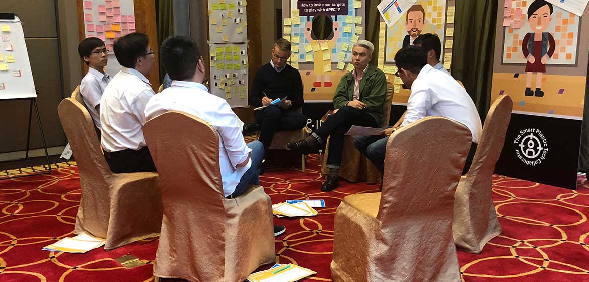 Covestro Shanghai participants seated in a circle in front of X-IDEA posters and sticky-note walls