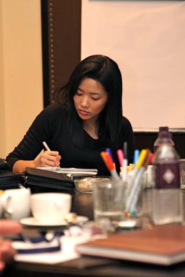 Participant taking notes at a table with markers and cups in the Deutsche Bank workshop