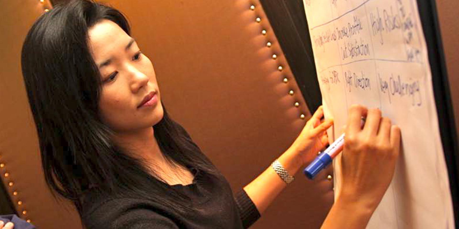Participant writing ideas on a flipchart in the Deutsche Bank strategy workshop