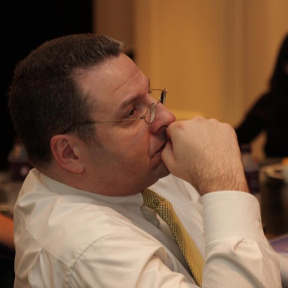 Deutsche Bank participant listening thoughtfully, hand at his chin