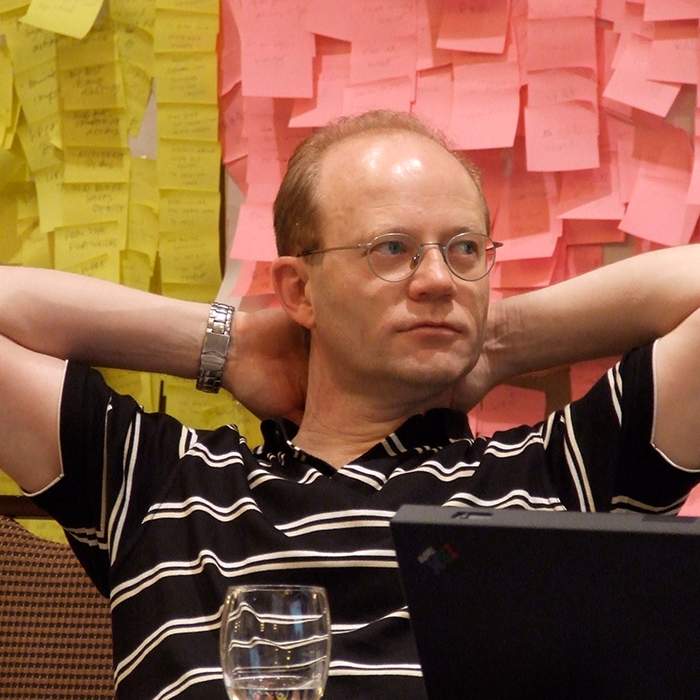 Participant leaning back in front of walls of yellow and pink sticky notes, Beiersdorf project