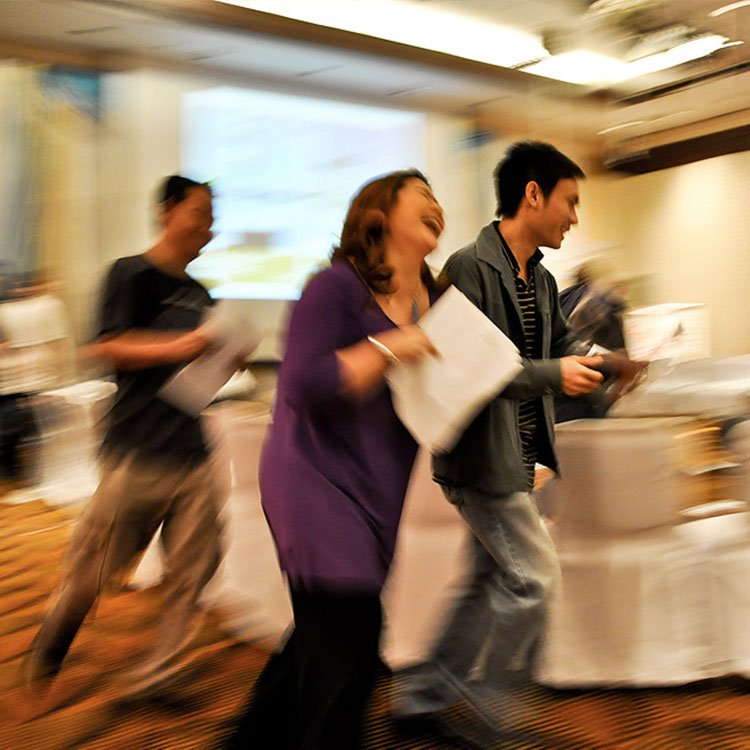 Mattel participants hurrying across the workshop room holding papers