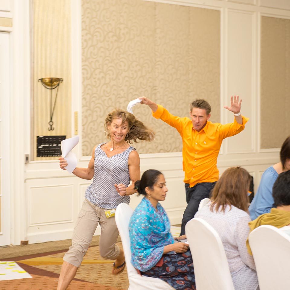 Participant and facilitator running with papers in a UNICEF energizer game
