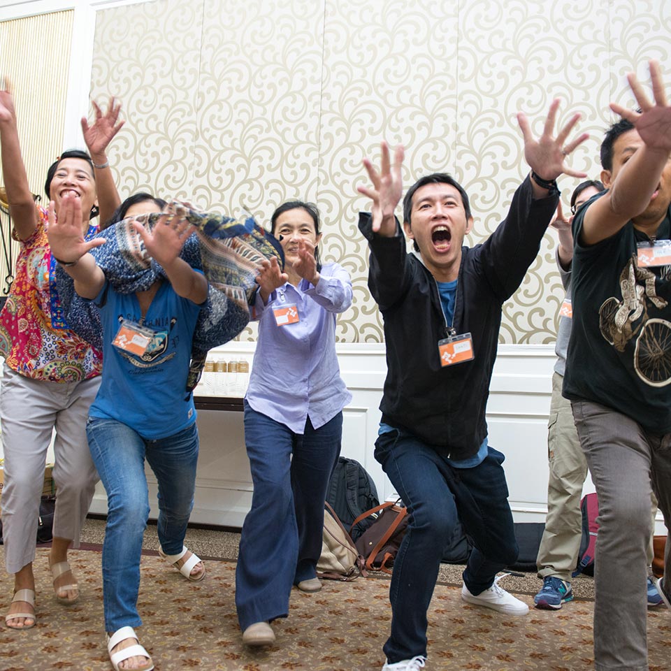 UNICEF staff cheering with arms raised in a high-energy group exercise