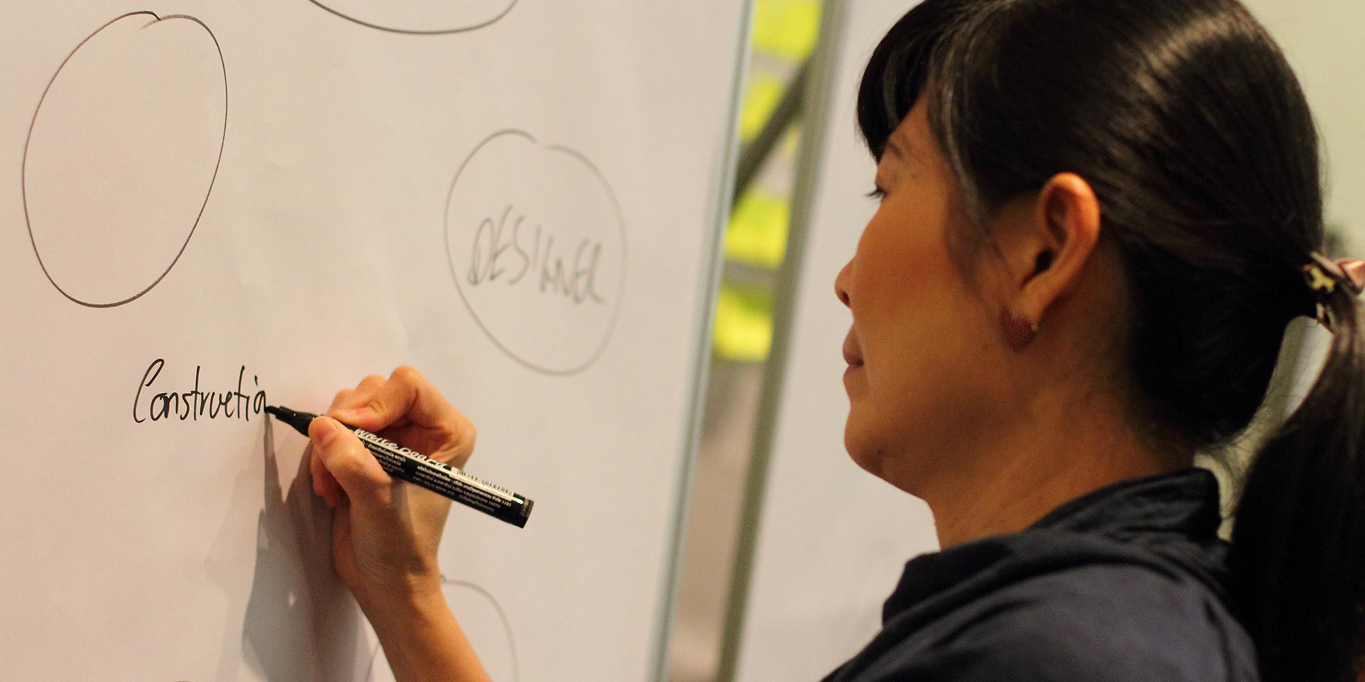 Participant writing on a whiteboard mind map, Nestle value innovation project