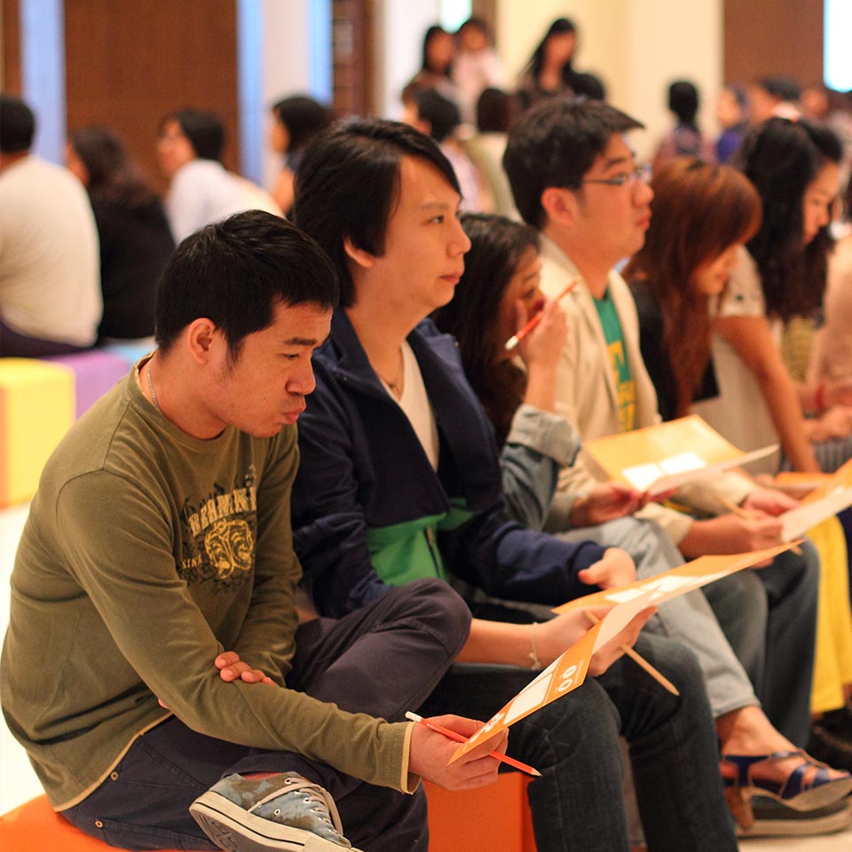 Nestle participants seated in a row filling in worksheets
