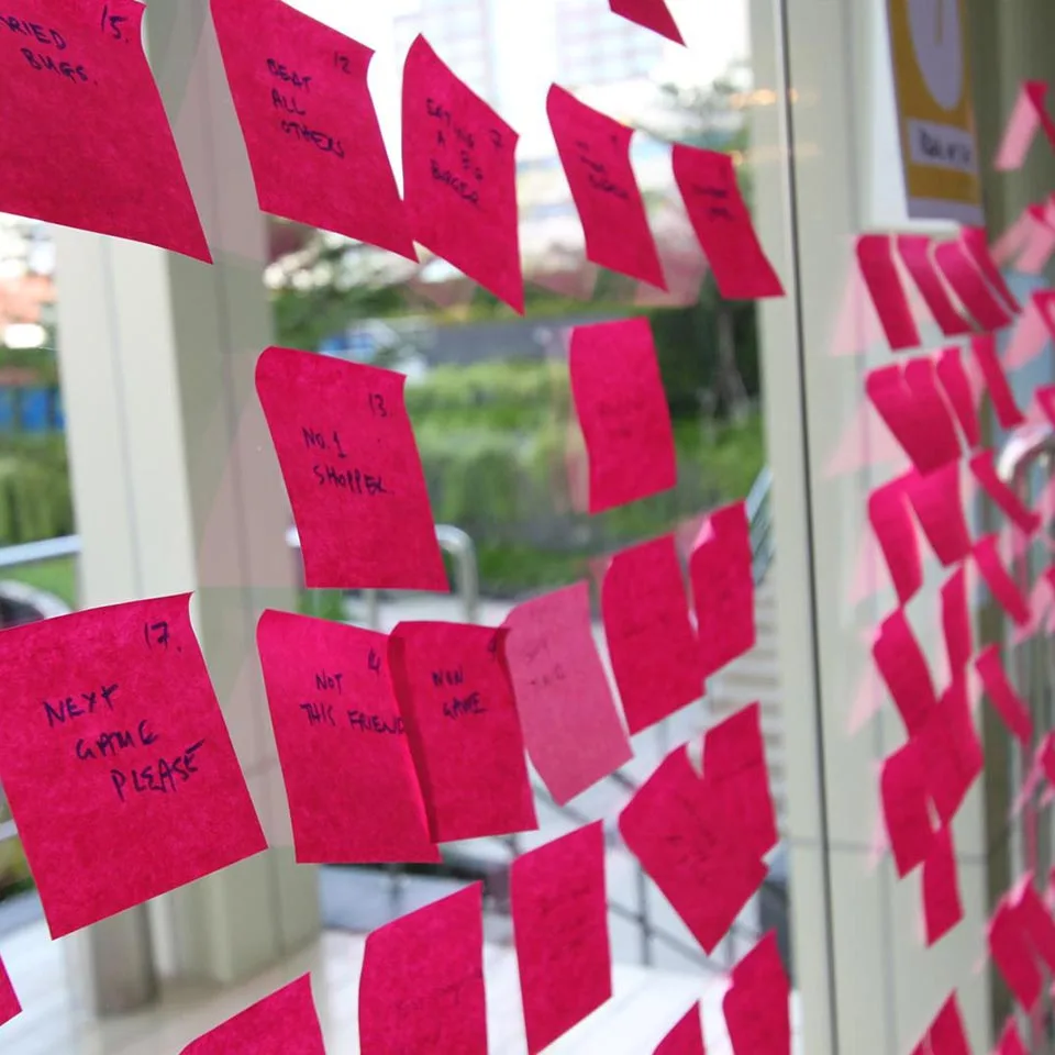 Pink sticky notes with ideas stuck on a glass window, Sandbox Global project