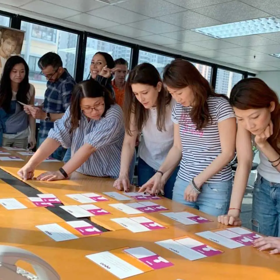 Brasia consultants sorting TIPS cards laid out along a conference table