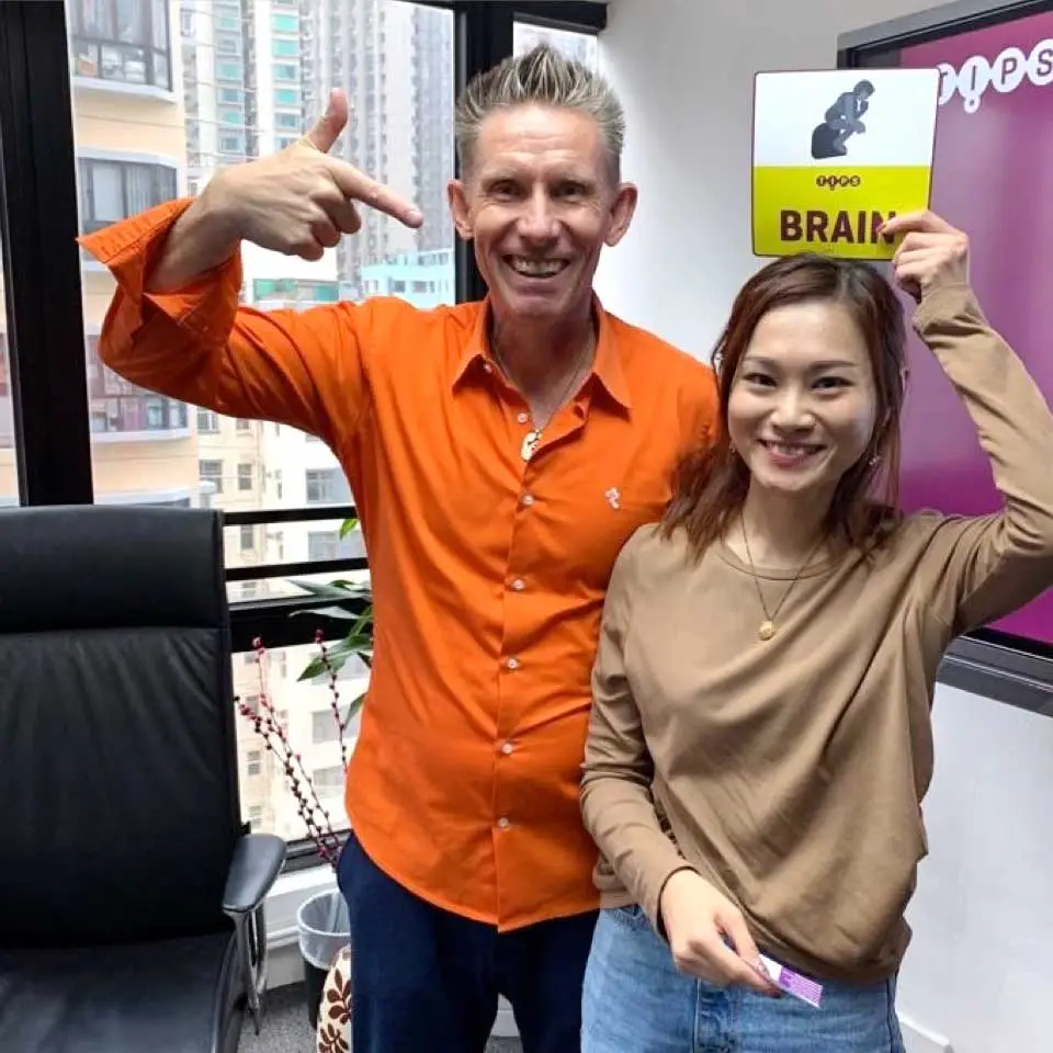 Facilitator and participant posing with a TIPS Brain card at the Brasia team event