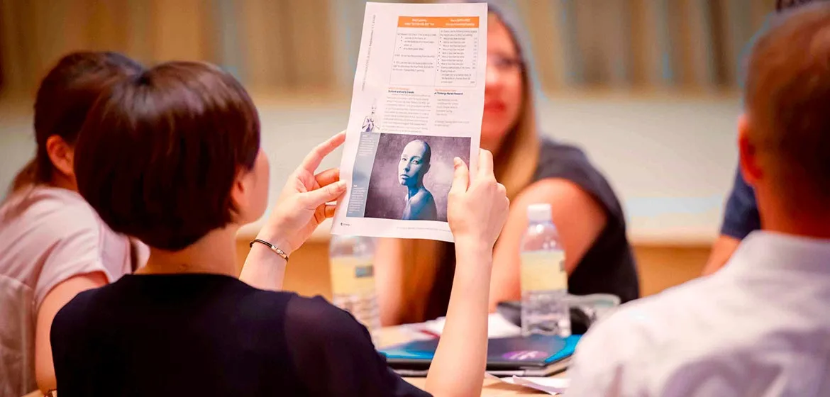 Participant holding up a worksheet with a portrait image in the Covestro workshop